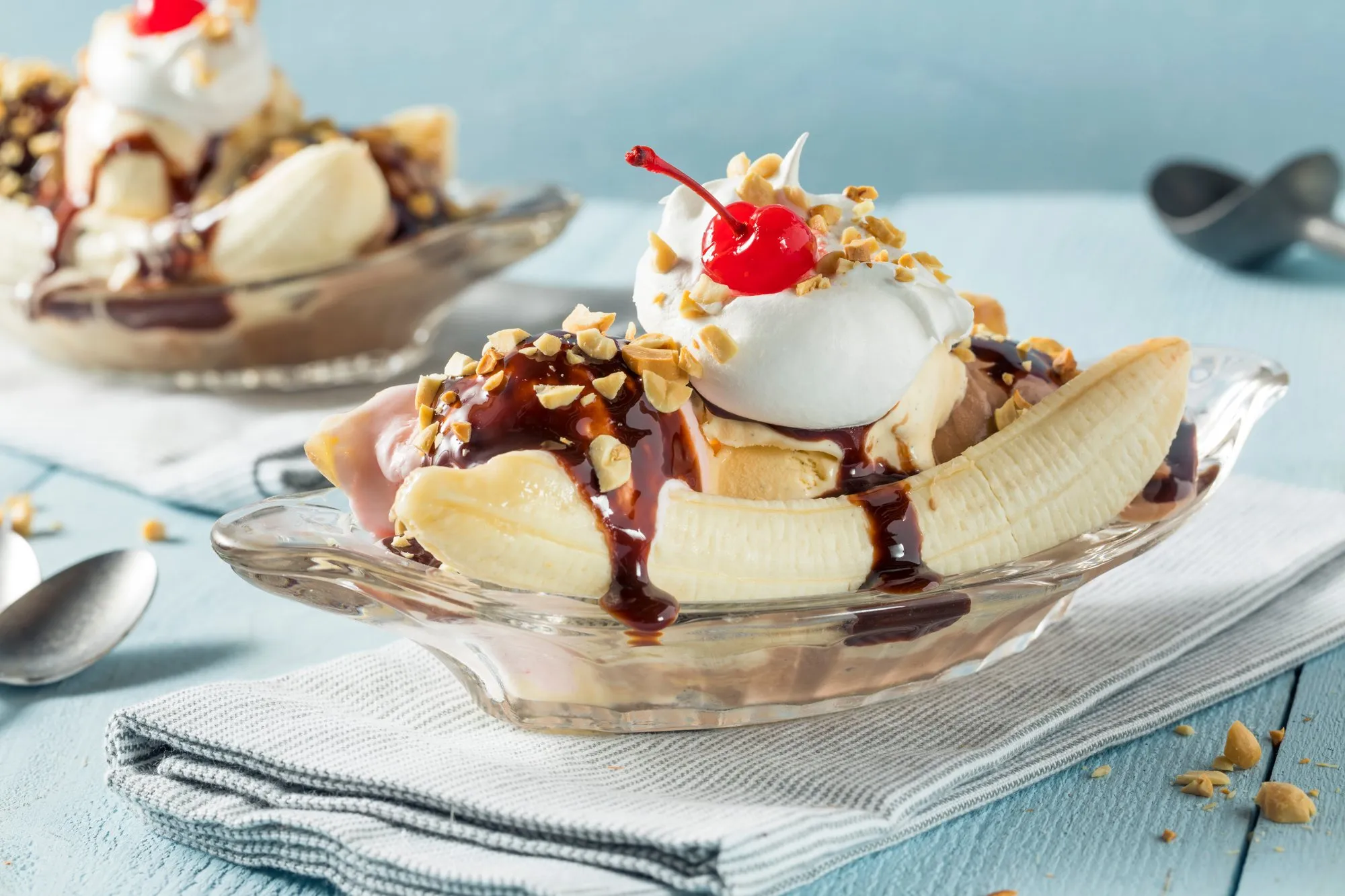 A banana split with scoops of ice cream, chocolate sauce and cherries