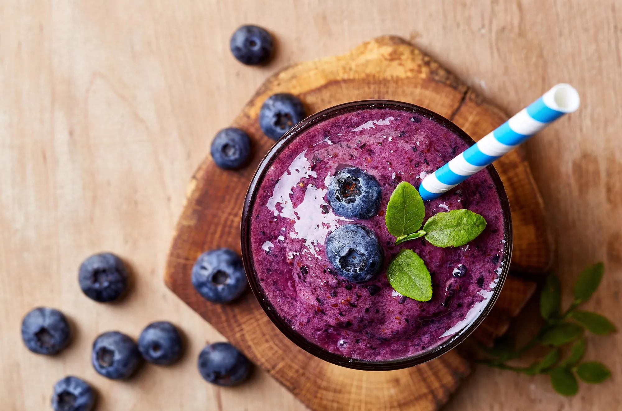 A blueberry smoothie with fresh blueberries and mint