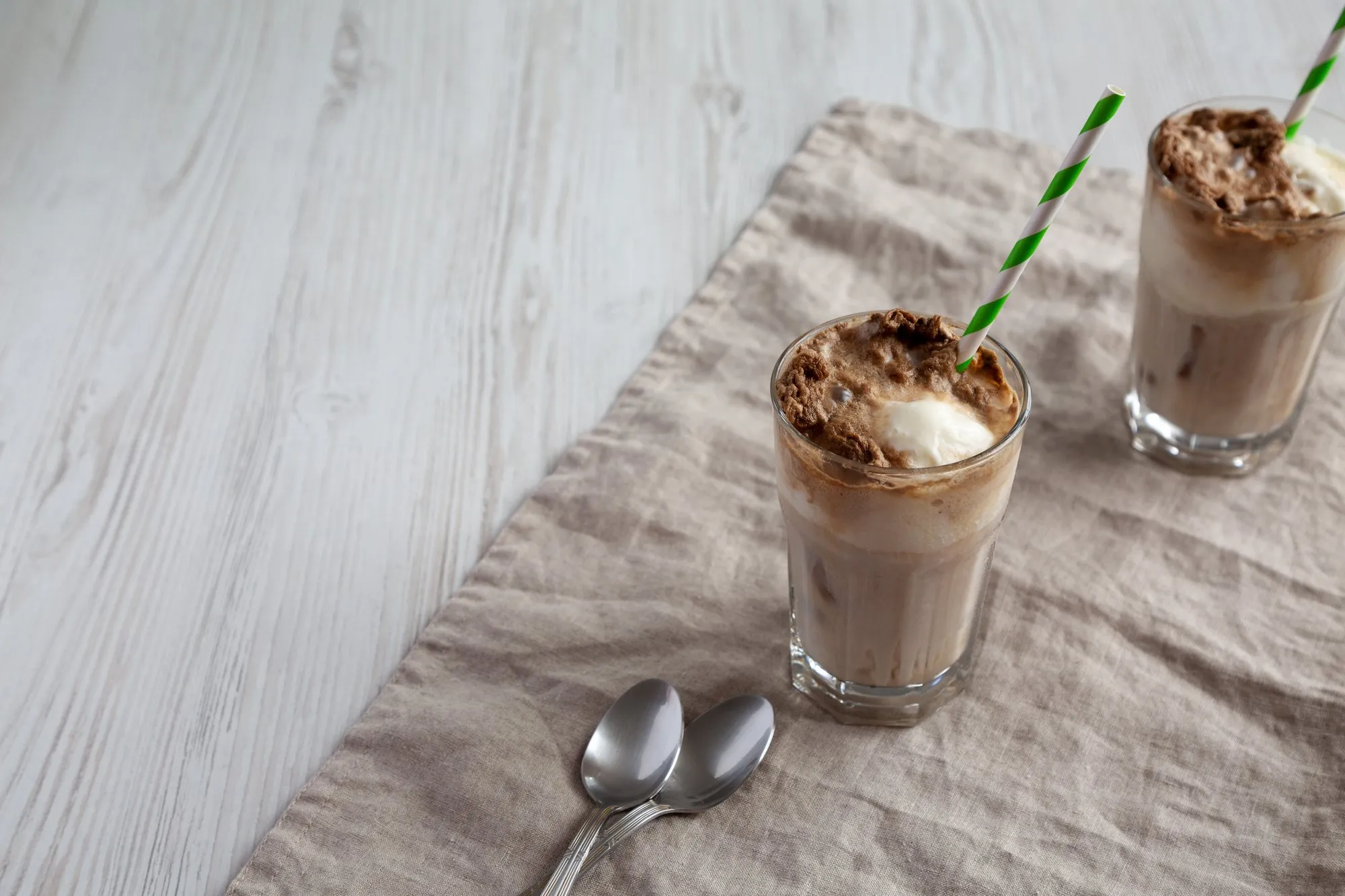 Two chocolate milkshakes with straws