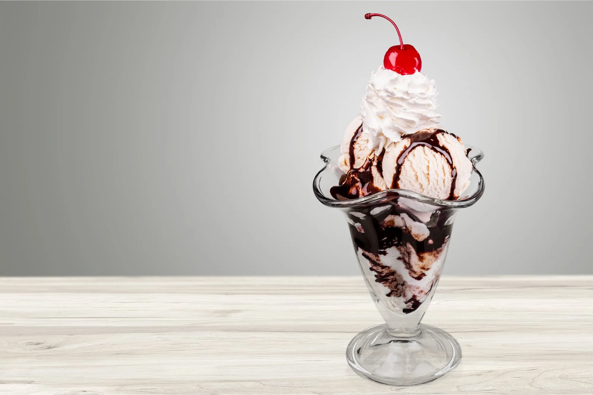 A sundae in a glass with whipped cream and a cherry